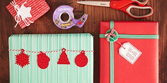 Een traditionele kerstcadeauverpakking creëren met rood, groen en wit kleuren, en papieren figuren bevestigen met Scotch® Dubbelzijdige Tape
