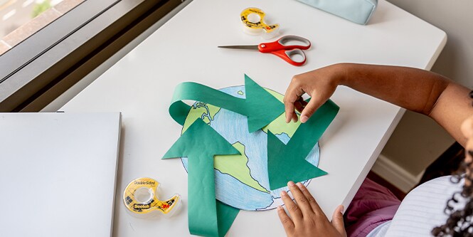 Meisje dat een wereldkaart van papier maakt met Scotch™ Merk benodigdheden
