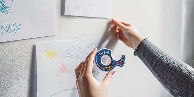 Kinderkunst ophangen aan een muur met Scotch® Wall-Safe Tape
